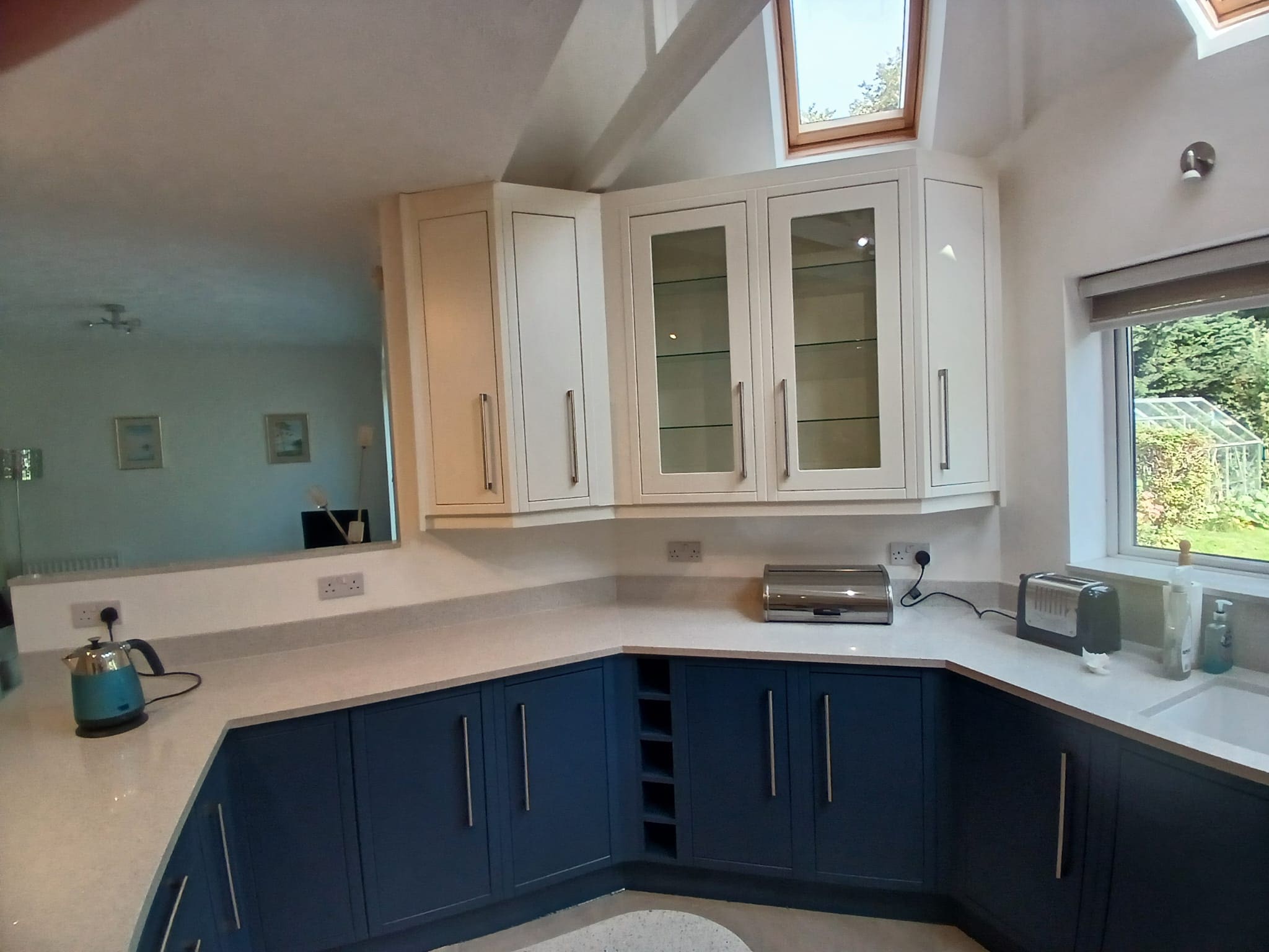 Two-tone kitchen with white upper and deep blue lower cabinets in Leeds