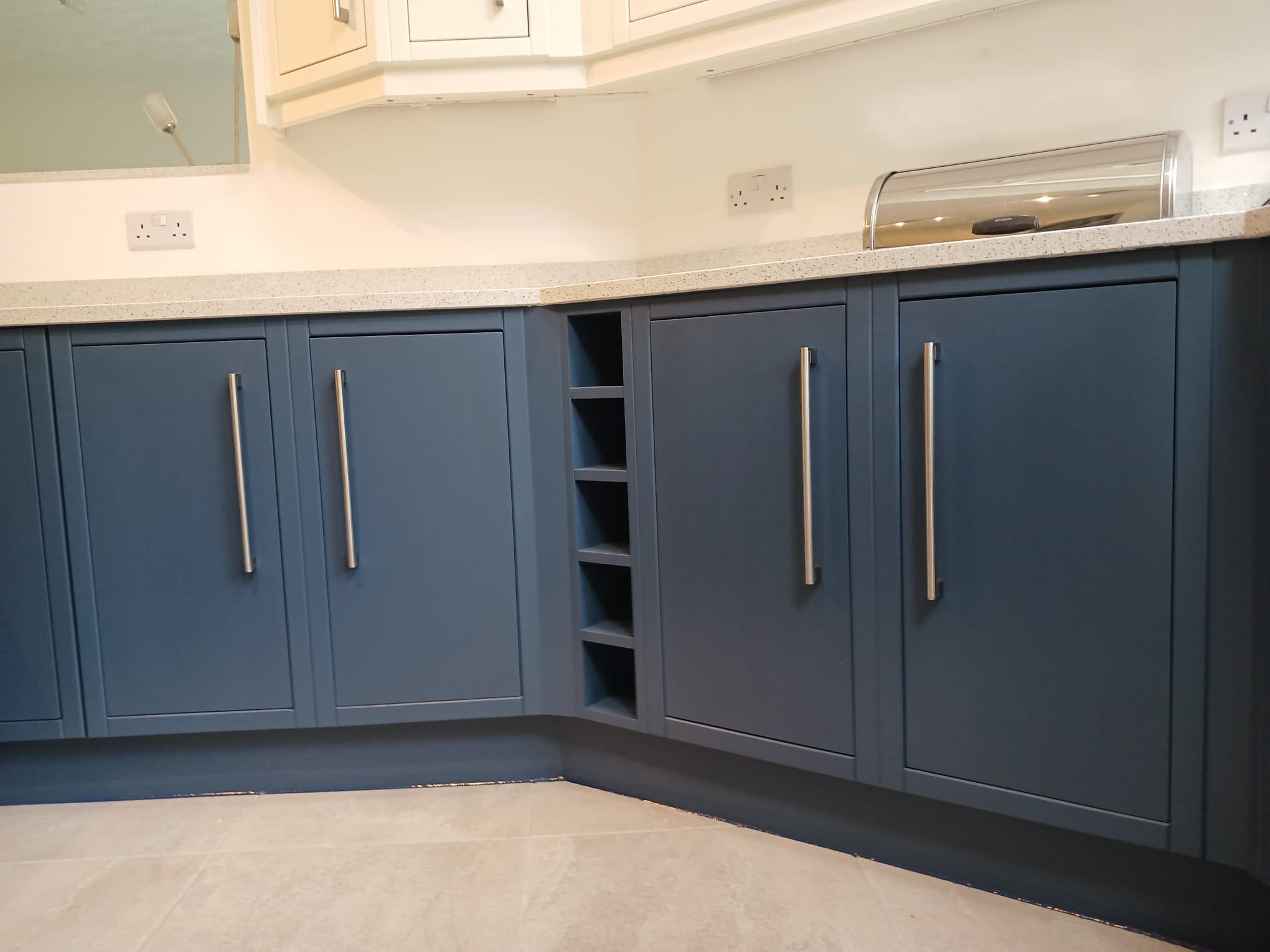 Deep blue kitchen cabinets and wine rack refinished in Leeds